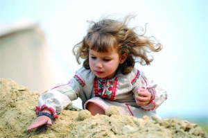 Дівчинка бавиться у піску на фестивалі ”Трипільське коло” у місті Ржищів на Київщині