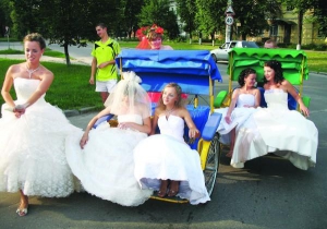 Участницы парада невест в субботу катаются на велорикшах возле парка ”Победа” в Полтаве