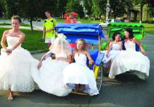 Участницы парада невест в субботу катаются на велорикшах возле парка ”Победа” в Полтаве