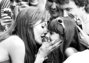 Голливудская актриса Анджелина Джоли целует одну из фанаток под московским кинотеатром ”Октябрь”, где презентовали фильм ”Солт”