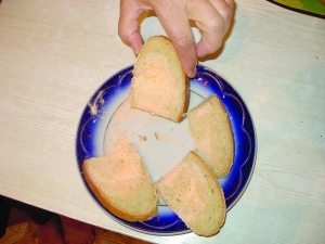Вінничанка Ганна Лукіянчук показує скибки хліба, вкриті пліснявою червоного кольору. Вважає, що в продукті є шкідливі домішки