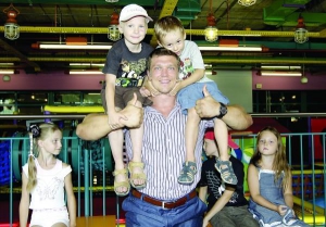 Киянин Сергій Конюшок тримає на плечах двох хлопчиків у столичному розважальному центрі ”Дивосвіт”. Торік він виборов звання ”Найсильніша людина світу”