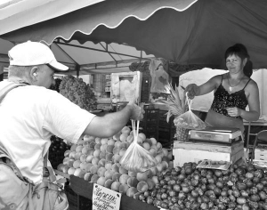 Юрій Голубець купує персики на столичному ринку Фермер. Платить 11 гривень за кілограм. На інших ринках ціна — до 20 гривень
