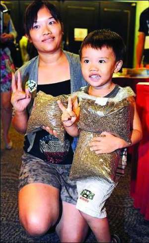 Хуанг Юен вместе с сыном держат пакеты с подстреленными москитами. Жюри оценило, что в пакетах четыре миллиона насекомых