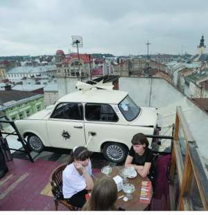 Відвідувачки львівського ресторану ”Дім легенд” сидять за столиком на терасі, яку називають залом львівської погоди