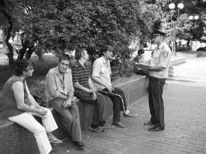 Старший участковый Иван Грицюк (справа) в пятницу делает обход в центре Коломыи. В сквере подходит к компании из трех мужчин и женщины. Женщина пила пиво. Увидела милиционера и сразу выбросила полупустую бутылку в мусорник