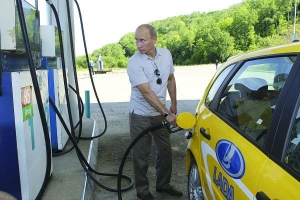 Российский премьер-министр Владимир Путин заливает горючее в автомобиль ”Лада Калина Спорт” в Хабаровской области. Чтобы проверить качество новой дороги, он проехал по ней две тысячи километров