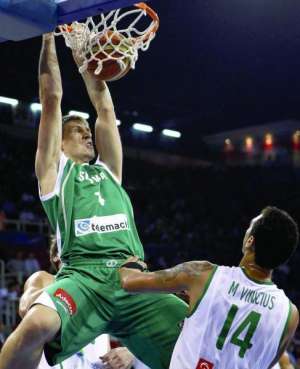 Словенский баскетболист Гаспер Видмар забивает ”сверху” в матче с командой Бразилии