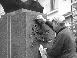 Робітники змивають розчинником чорну фарбу з постаменту під погруддям Ярославові Стецьку у центрі Тернополя