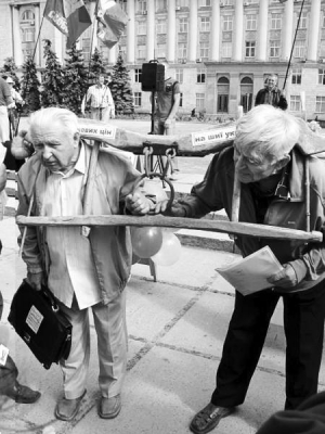 Черкасчане Филипп Шепельский (с портфелем) и Петр Кривдик надели на шею ярмо возле облсовета. Протестовали 8 сентября против поднятия цен на газ
