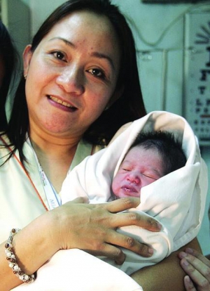 Медсестра Кейт Кальво держит новорожденного, которого нашли в мусорном пакете в аэропорту Манилы