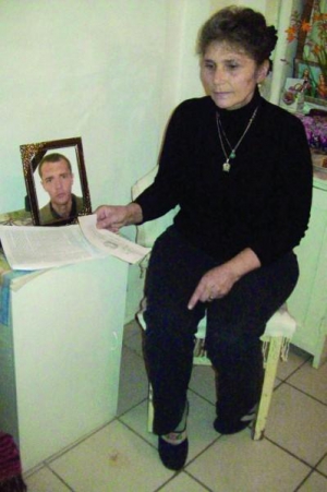Львів’янка Наталія Стадник сидить поряд із портретом загиблого сина Михайла. На його тілі експерти нарахували 51 забій