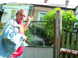 Мар’ян Німіцький показує на свій будинок по вулиці Художній у Полтаві. У хаті через сповзання землі просіла підлога. Зривати її чоловік боїться, бо дім зруйнується