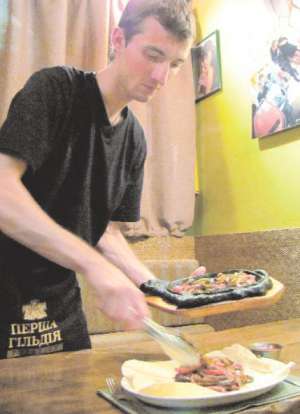 Евгений Сенин, шеф-повар столичного ресторана ”Эл матэ”, готовит фахитос — традиционное аргентинское блюдо. Жареные в вине овощи и мясо выкладывает на лаваш