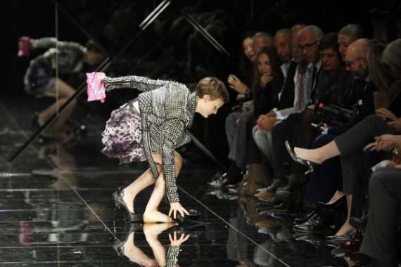 Модель спотыкается и подворачивает ногу во время дефиле на Парижской неделе моды. Высота ее каблуков 14 сантиметров. Показ девушка завершила босиком
