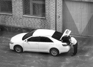 Водій губернатора Житомирщини Сергія Рижука порається біля нової службової машини ”Тойота Камрі”