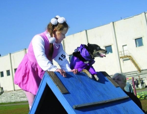 Черкасчанка Анна играет с собакой Кукусей на стадионе технологического университета. Там провели выставку беспородных псов