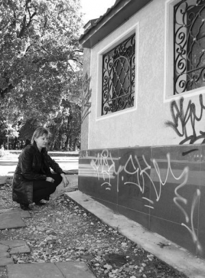 Тернополянка Наталя Оплета показує написи графітників на своєму будинку на вулиці Шухевича. Малюнки на плитці пробувала зчищати жорсткою щіткою, однак сліди залишилися