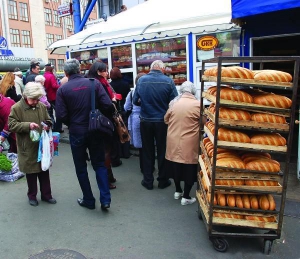 Покупатели стоят в очереди к хлебному киоску возле станции метро Лукьяновская во вторник в обед. Черный хлеб покупают значительно чаще, чем батон