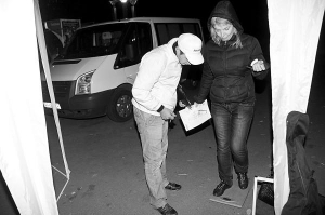 Волонтер Киевского международного института социологии взвешивает киевлянку возле метро Политехнический институт вечером 11 октября
