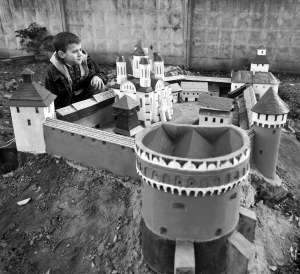 Школьник Павел Трохановский осматривает уменьшенную копию Острожского замка в парке фортификационных сооружений в миниатюре