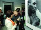 Відвідувачки галереї п’ють вино біля світлини боксера Майкла Тайсона з білим голубом у руках