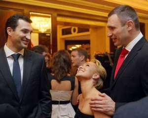 Віталій Кличко (праворуч) спілкується з меншим братом Володимиром і його дівчиною американською актрисою Хайден Пенеттьєрі 