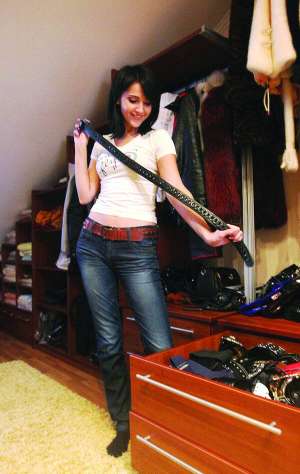 Київська співачка Марта витягує з шафи у гардеробній кімнаті пасок