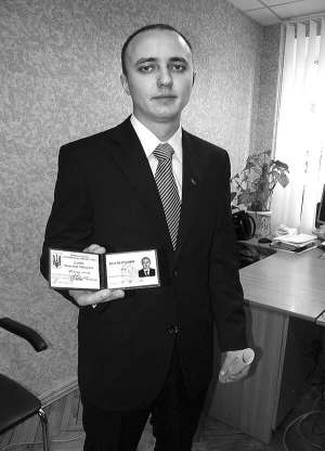 Олександр Качур в кабінеті юриста Немирівської міської ради Євгенії Подзігун показує посвідчення мера