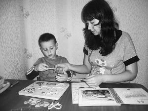 Психолог Євгенія Полтенко у столичному центрі сімейної психології ”Фелічіта” допомагає хлопчикові складати картинки