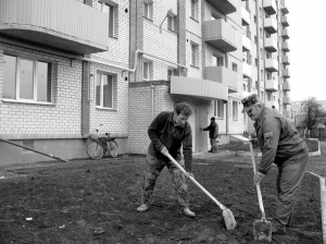 Будівельники Сергій Соболєв (ліворуч) і Сергій Прохоренко рівняють землю на газоні перед новобудовою в центрі Миргорода