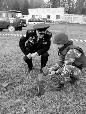 Неподалік бази аварійно-рятувальної частини МНС піротехнік Сергій Гайдеш (праворуч) показує Анатолію Жукову навчальний артснаряд