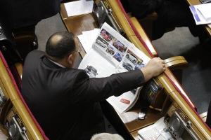 Зранку в сесійній залі парламенту нардеп від Партії регіонів Володимир Личук розглядає в газеті автомобілі