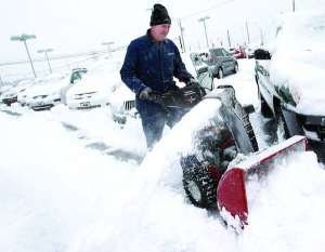 Працівник автосалону ”Кіа” Джо Амарро розчищає від снігу автомобіль 13 грудня в місті Медина, в Огайо