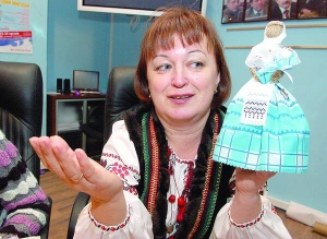Майстриня з міста Вишгород під Києвом Олена Кольвах тримає ляльку-мотанку в українському вбранні