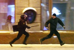 Омонівець біжить за чоловіком у неділю в центрі білоруської столиці Мінська