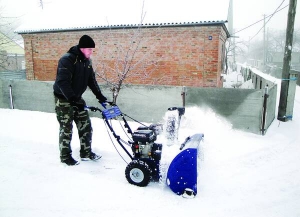 Дорожній майстер з Христинівки 28-річний Сергій Тихонюк чистить тротуар від снігу  ручним агрегатом