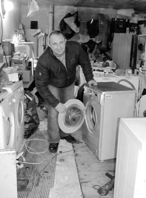 Майстер Володимир Олексієнко у своїй майстерні показує пральну машину ”Індезіт”