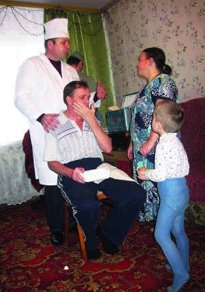 Незрячий Віктор Гижко (на стільці) тримається рукою за щоку