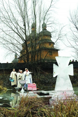 У козацькому селищі ”Мамаєва Слобода” біля церкви Покрови Пресвятої Богородиці в Києві священики освячують воду об 11.00 ранку 19 січня цього року 