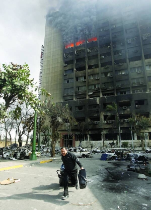 Мародер тікає з палаючої будівлі керівної Націонал-демократичної партії в Каїрі