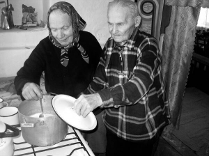 Дем’ян Сорокопуд із села Лопатинці на Вінниччині кип’ятить молоко на кухні зі своєю дружиною Марією Плащевською