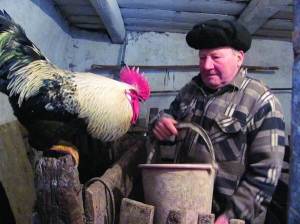 Михайло Левченко з села Лісового на Черкащині тримає відро пшениці