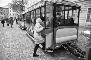 Туристи сідають у ”чудо-поїзд”, що відправляється від міської ради у Львові