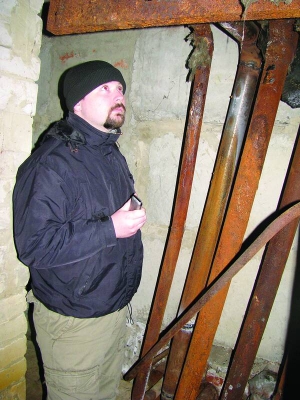 Юрій Півень показує іржаві труби в підвалі будинку. Жильці вважають, що його спорудили з бракованих матеріалів