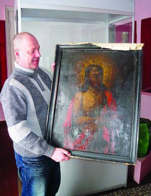 Виконувач обов’язків директора Уманського краєзнавчого музею Юрій Торгало показує образ Ісуса Христа. Ікона стоїть за склом в одному з залів, де працює виставка ”Таємничий світ православної ікони”