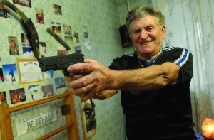 Киянин Володимир Моногаров  тримає у руках газовий пістолет у своїй однокімнатній квартирі на Русанівці. Його купив, щоб захищатися від грабіжників