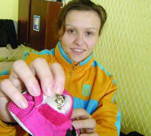 Чемпіонка Європи з вільної боротьби 2009 року Наталя Синишина показує хрестик, захований у підкладку кросівка. Носити ланцюжки і сережки їй не дозволяє тренер