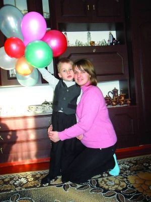 Тетяна Кугай з сином Максимом у хаті батьків у райцентрі Іллінці Вінницької області. Жінка не може влаштуватися на роботу через вивих плеча