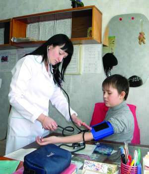Медсестра Гадяцької гімназії №1 Юлія Швець вимірює тиск в учня 7 класу Дмитра Давиденка